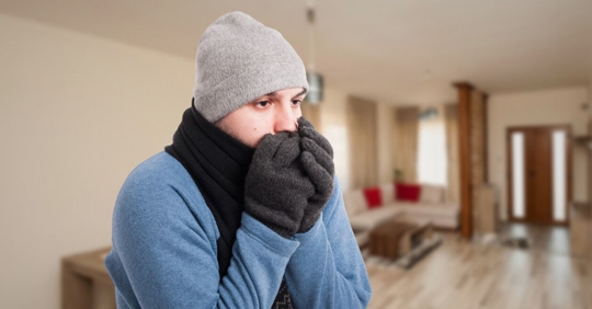 Young man feeling cold and warming his hands